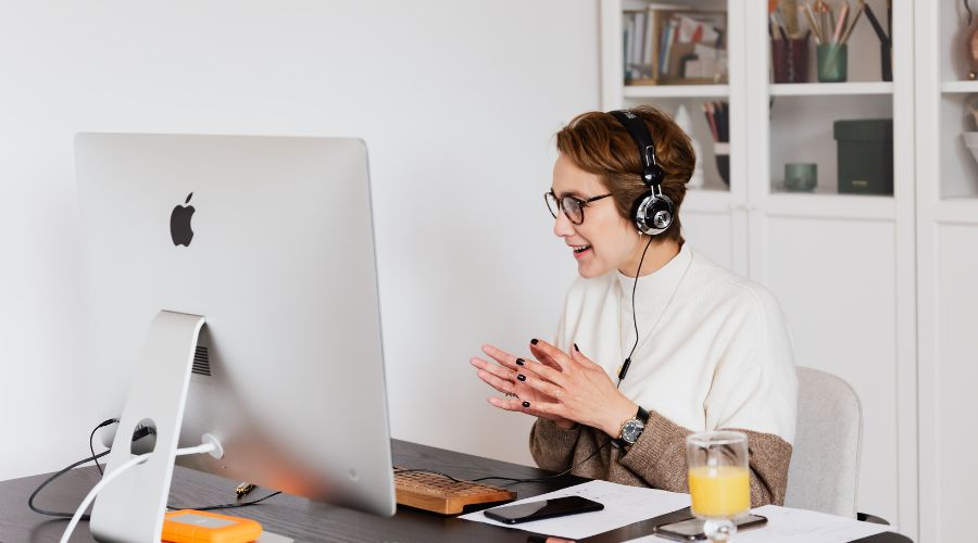 Virtual medical assistant with headset working on patient records at a computer in a clinic setting